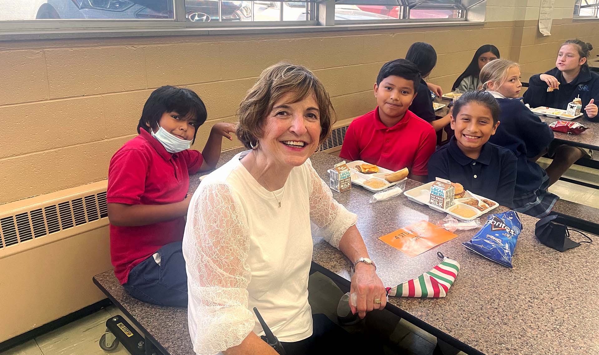 Jeanne Von Feldt with kids in cafeteria at All Saints