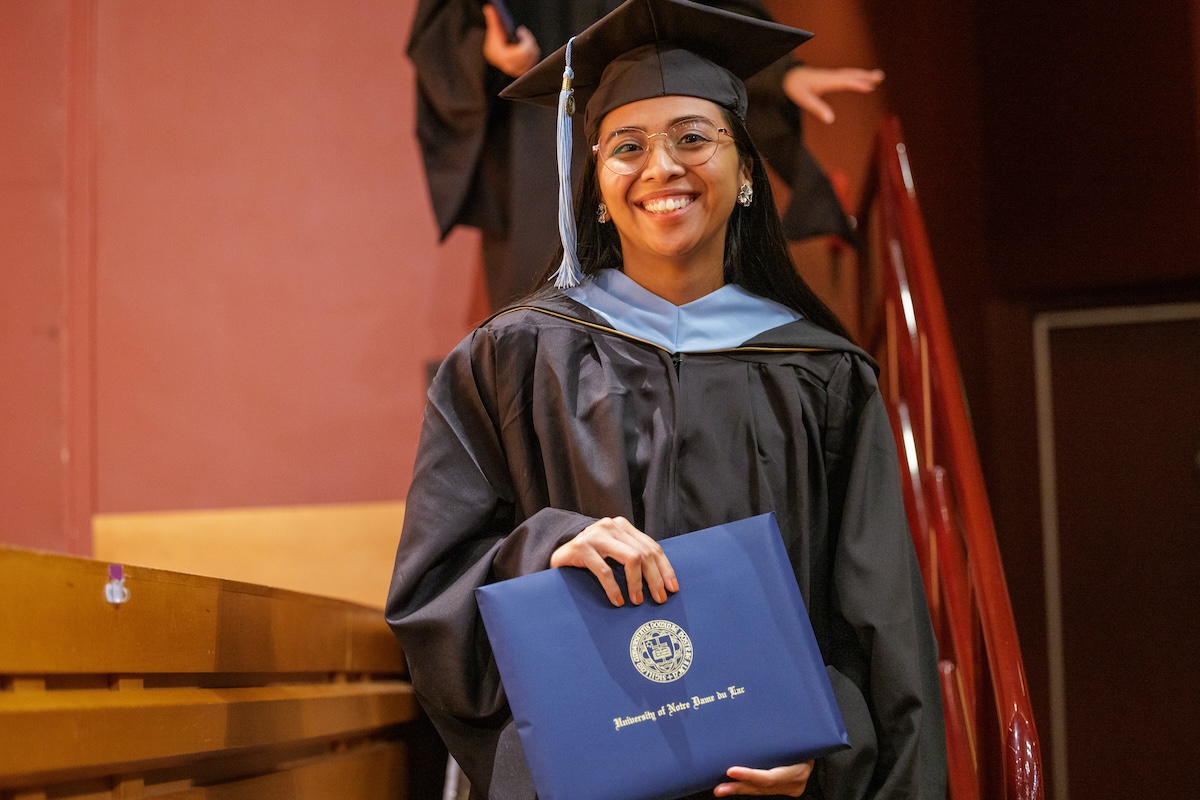 Naomi Hernandez with her M.Ed. diploma walking off stage at Commencement