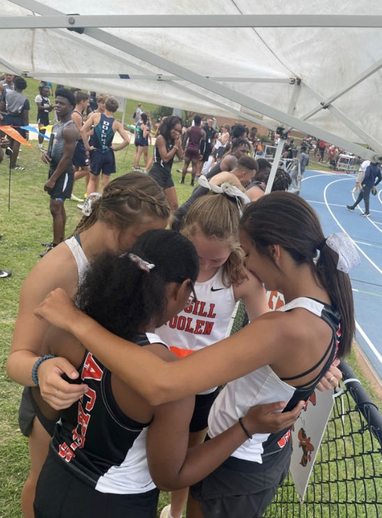 Girls huddle in prayer before the state track meet