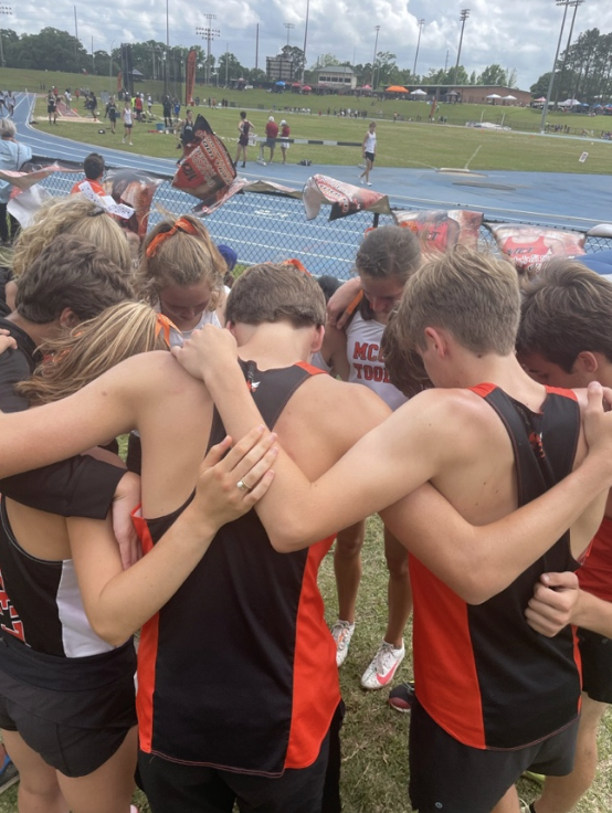 Boys huddle in prayer before the state track meet