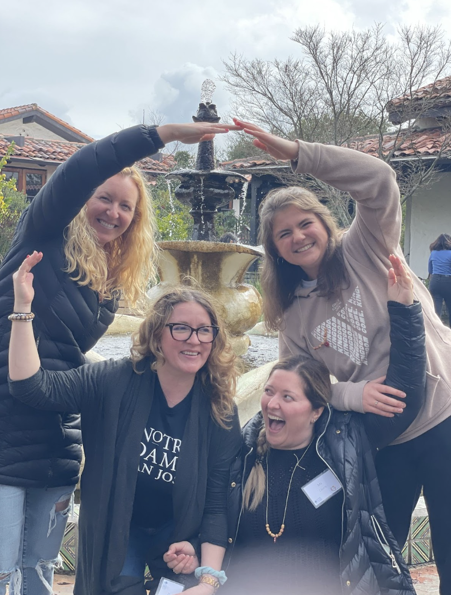 Emma and some teachers on retreat making a heart with their arms