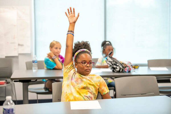 Valerie, 9, a student in the Summer Scholars program at Robinson Community Learning Center, raises her hand with the correct answer to a math problem. (Photos by Barbara Johnston/University of Notre Dame)