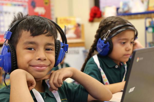 Student smiling, wearing headphones