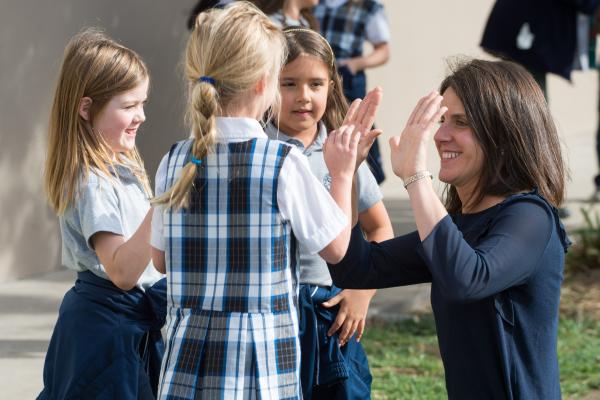 Teacher high-fiving students
