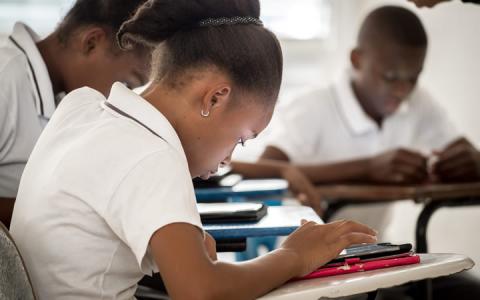 Student writing at desk